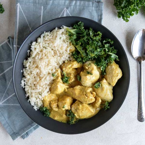 Coconut Butter Chicken topped with Kale and cauliflower rice